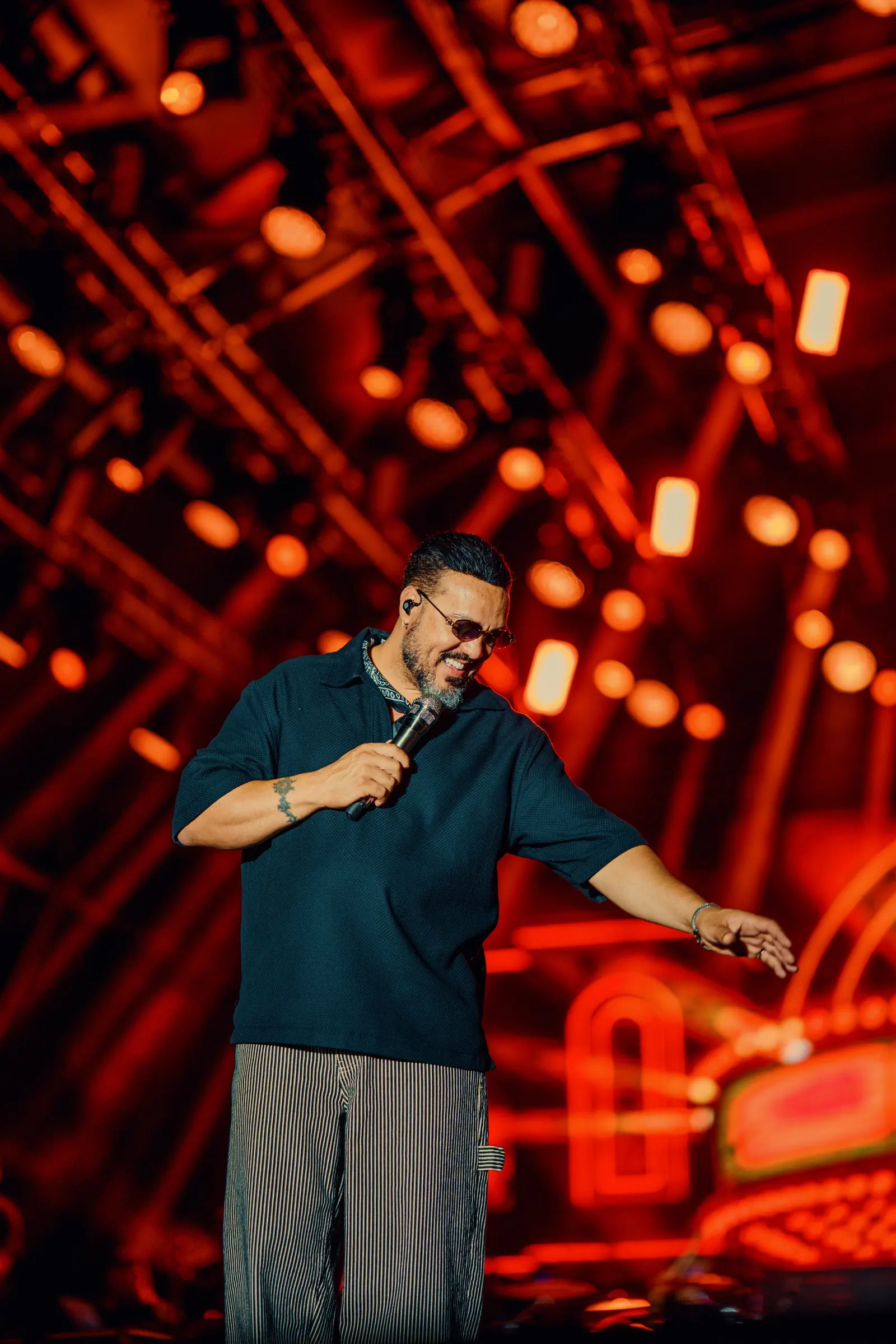 Festival de Verão Cabo Frio — Cantor se apresentando sob luzes vermelhas