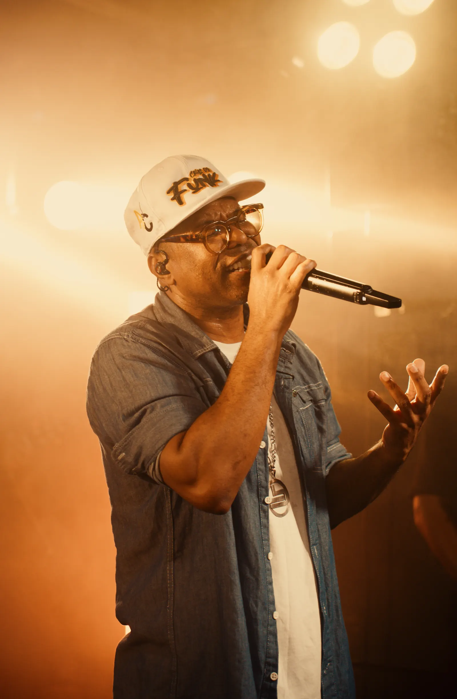 Camarote Favela — Cantor de chapéu durante apresentação ao vivo